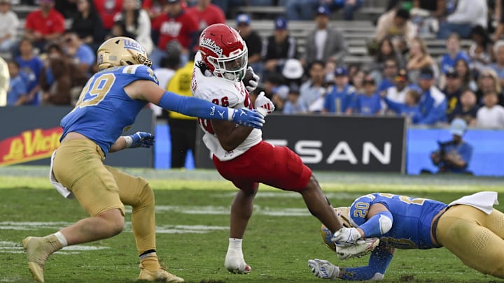 Nov 30, 2024; Pasadena, California, USA; UCLA Bruins linebacker Carson Schwesinger (49) and linebacker Kain Medrano (20) stop Fresno State Bulldogs running back Bryson Donelson (26) in the fourth quarter at Rose Bowl. Mandatory Credit: Robert Hanashiro-Imagn Images