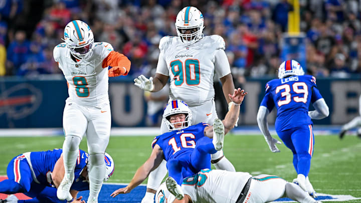 Buffalo Bills punter Cameron Johnston (16) is roughed by Miami Dolphins defensive tackle Zach Sieler (92) resulting in a first down in the fourth quarter at Highmark Stadium.