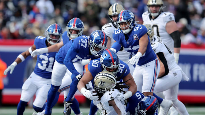 Dec 8, 2024; East Rutherford, New Jersey, USA; New Orleans Saints running back Alvin Kamara (41) is tackled by New York Giants cornerback Tre Hawkins III (37) and defensive end Elijah Garcia (90) and linebacker Darius Muasau (53) and linebacker Kayvon Thibodeaux (5) during the first quarter at MetLife Stadium. Dec 8, 2024; East Rutherford, New Jersey, USA; New Orleans Saints running back Alvin Kamara (41) is tackled by New York Giants cornerback Tre Hawkins III (37) and defensive end Elijah Garcia (90) and linebacker Darius Muasau (53) and linebacker Kayvon Thibodeaux (5) during the first quarter at MetLife Stadium.
