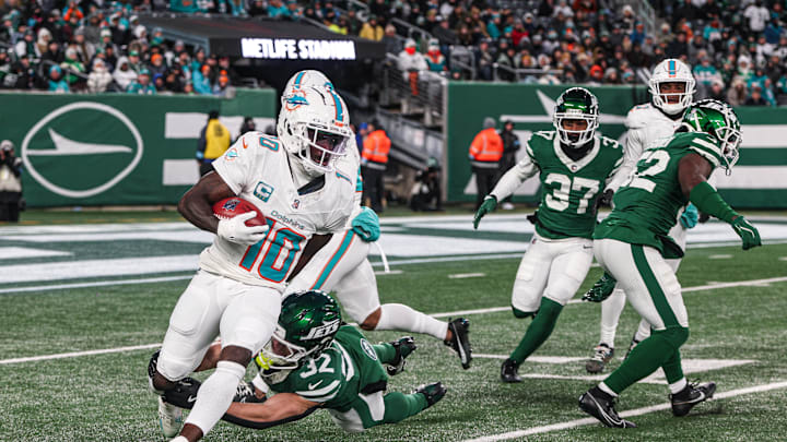 Miami Dolphins wide receiver Tyreek Hill (10) is tackled by New York Jets running back Isaiah Davis (32) during a punt return during the first half at MetLife Stadium in the 2024 season finale.