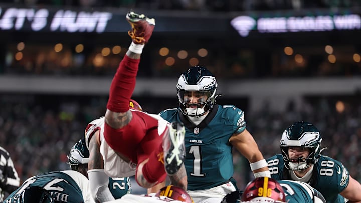Jan 26, 2025; Philadelphia, PA, USA; Philadelphia Eagles quarterback Jalen Hurts (1) reacts as Washington Commanders linebacker Frankie Luvu (4) leaps over linemen before a snap during the second half in the NFC Championship game at Lincoln Financial Field. Mandatory Credit: Bill Streicher-Imagn Images