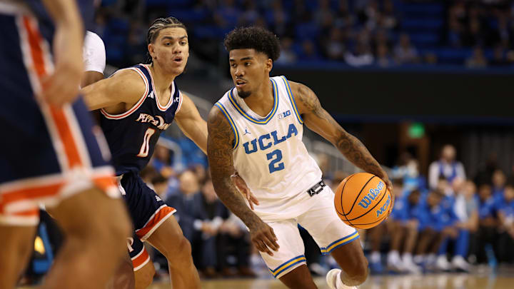 Nov 7, 2025; Los Angeles, California, USA;  UCLA Bruins guard Donovan Dent (2) dribbles the ball around Pepperdine Waves guard Styles Phipps (0) during the first half at Pauley Pavilion presented by Wescom Financial. Mandatory Credit: Kiyoshi Mio-Imagn Images