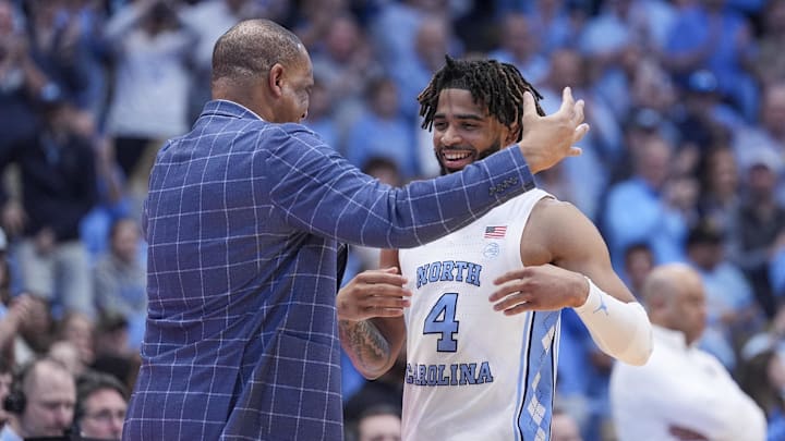 Mar 5, 2024; Chapel Hill, North Carolina, USA; North Carolina Tar Heels head coach Hubert Davis hugs guard RJ Davis (4) on senior night during the second half against the Notre Dame Fighting Irish at Dean E. Smith Center. Mandatory Credit: Jim Dedmon-USA TODAY Sports