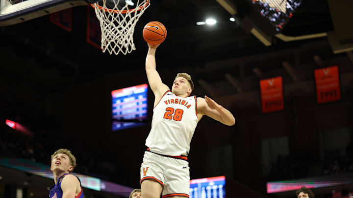 Dec 22, 2025; Charlottesville, Virginia, USA; Virginia Cavaliers forward Thijs de Ridder (28) dunks the ball as American University Eagles forward Matt Mayock (33) and  Eagles forward Chris Eagan (35) look on in the second half at John Paul Jones Arena. Mandatory Credit: Geoff Burke-Imagn Images