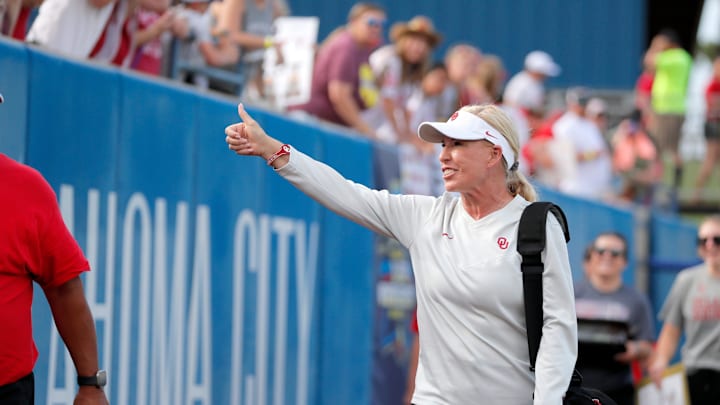 Oklahoma coach Patty Gasso gestures to fans as she walks on the field before Game 2 of the NCAA softball Women's College World Series Championship Series game between the Oklahoma Sooners and Texas Longhorns at Devon Park in Oklahoma City, Thursday, June 6, 2024.