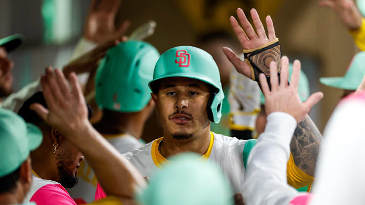Aug 22, 2025; San Diego, California, USA; San Diego Padres third baseman Manny Machado (13) celebrates in the dugout after scoring a run during the fourth inning against the Los Angeles Dodgers at Petco Park. Mandatory Credit: David Frerker-Imagn Images