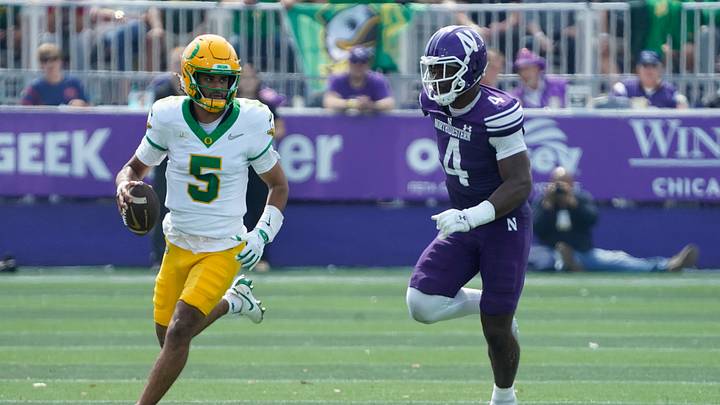 Oregon Ducks quarterback Dante Moore (5) runs the ball past Northwestern Wildcats defensive lineman Anto Saka (4) during the first half at Northwestern Medicine Field at Martin Stadium. Oregon Ducks quarterback Dante Moore (5) runs the ball past Northwestern Wildcats defensive lineman Anto Saka (4) during the first half at Northwestern Medicine Field at Martin Stadium.