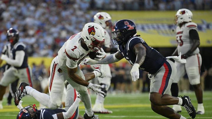 Sep 6, 2026; Nashville, Tennessee, USA; Louisville Cardinals wide receiver Treyshun Hurry (2) looks to break the tackle attempt by Mississippi Rebels defensive end Blake Purchase (3) during the first quarter at Nissan Stadium. Mandatory Credit: Steve Roberts-Imagn Images Sep 6, 2026; Nashville, Tennessee, USA; Louisville Cardinals wide receiver Treyshun Hurry (2) looks to break the tackle attempt by Mississippi Rebels defensive end Blake Purchase (3) during the first quarter at Nissan Stadium. Mandatory Credit: Steve Roberts-Imagn Images