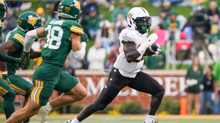Nov 1, 2025; Waco, Texas, USA; UCF Knights running back Myles Montgomery (22) carries the ball as Baylor Bears safety Jacob Redding (38) defends during the first half at McLane Stadium. Mandatory Credit: Raymond Carlin III-Imagn Images Nov 1, 2025; Waco, Texas, USA; UCF Knights running back Myles Montgomery (22) carries the ball as Baylor Bears safety Jacob Redding (38) defends during the first half at McLane Stadium. Mandatory Credit: Raymond Carlin III-Imagn Images