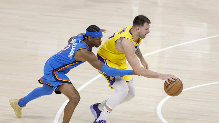 Apr 8, 2025; Oklahoma City, Oklahoma, USA; Oklahoma City Thunder guard Shai Gilgeous-Alexander (2) reaches to steal the ball from Los Angeles Lakers guard Luka Doncic (77) during the second half at Paycom Center. Mandatory Credit: Alonzo Adams-Imagn Images