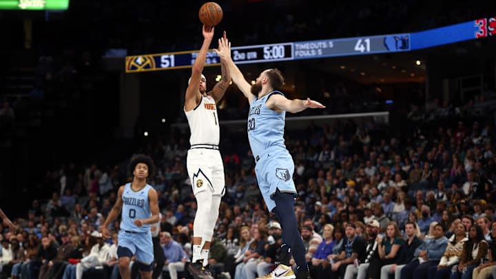 Nov 19, 2024; Memphis, Tennessee, USA; Denver Nuggets forward Michael Porter Jr. (1) shoots for three as Memphis Grizzlies center Jay Huff (30) defends at FedExForum. Mandatory Credit: Petre Thomas-Imagn Images