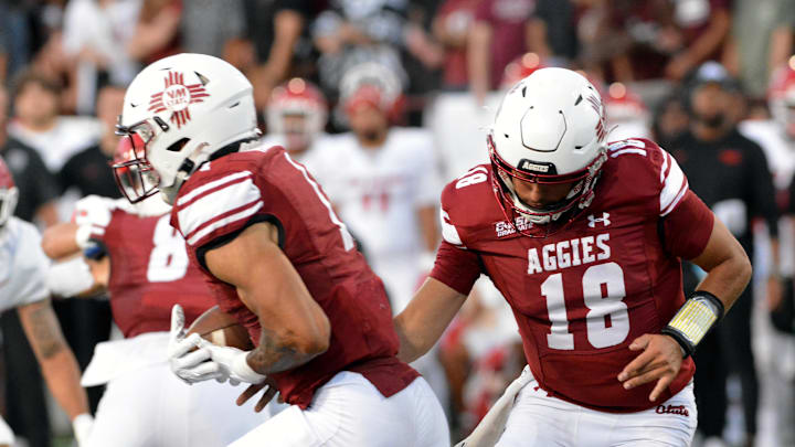 Seth McGowan (left) takes the ball from Aggie quarterback Santino Marucci (right) on a running play as the NMSU Aggies took on the UNM Lobos at Aggie Memorial Stadium. Seth McGowan (left) takes the ball from Aggie quarterback Santino Marucci (right) on a running play as the NMSU Aggies took on the UNM Lobos at Aggie Memorial Stadium.