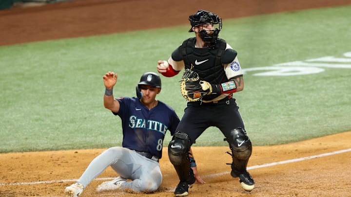 Texas Rangers catcher Jonah Heim (28) forces out Seattle Mariners right fielder Dominic Canzone (8) at home plate during the fourth inning at Globe Life Field on June 27. Texas Rangers catcher Jonah Heim (28) forces out Seattle Mariners right fielder Dominic Canzone (8) at home plate during the fourth inning at Globe Life Field on June 27.