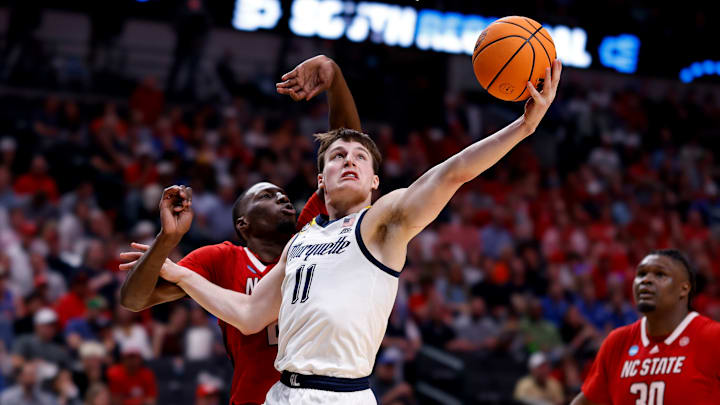 Number 11 in white-&-blue, Tyler Kolek, gets to the cup with the gangly Frenchman (/Diarra) draped all over him. Marquette's lefty point-guard was anAll Big East selection this year and a torn oblique in February didn't help him much from an outside-shooting standpoint. Hesitant to pull the trigger from-3 against NC State's matchup-zone, Kolek worked hard for his 17 points; but his and his team's struggles from-3 didn't allow them to score as well as they would've liked to on all 3 levels. 