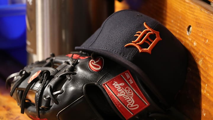 Navy blue Detroit Tigers hat sits on a black glove. Navy blue Detroit Tigers hat sits on a black glove.