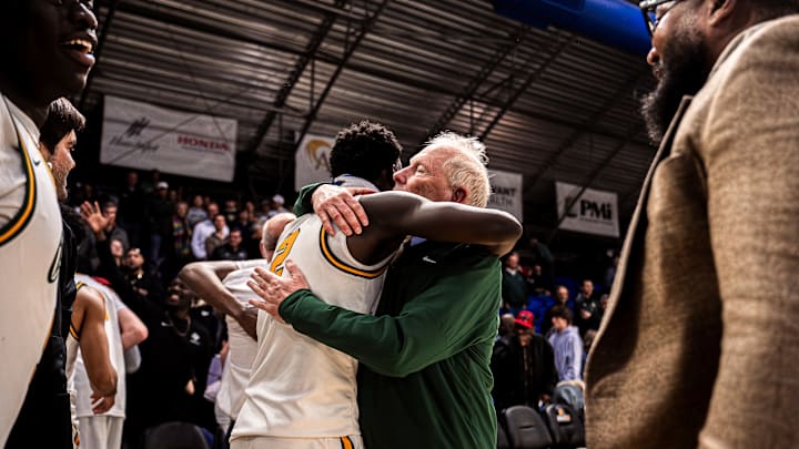 Greensboro Day boys basketball coach Freddy Johnson hugs one of his players after the Bengals captured their 14th state title in February with Johnson at the helm.