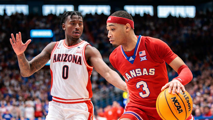 Mar 8, 2025; Lawrence, Kansas, USA; Kansas Jayhawks guard Dajuan Harris Jr. (3) drives to the basket around Arizona Wildcats guard Jaden Bradley (0) during the second half at Allen Fieldhouse. Mandatory Credit: William Purnell-Imagn Images