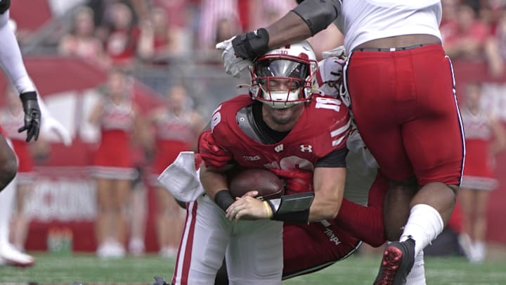 Sep 20, 2025; Madison, Wisconsin, USA; Wisconsin Badgers quarterback Danny O'Neil (18) is sacked by Maryland Terrapins linebacker Daniel Wingate (1) during the second quarter at Camp Randall Stadium. Mandatory Credit: Mark Hoffman/USA Today Network via Imagn Images