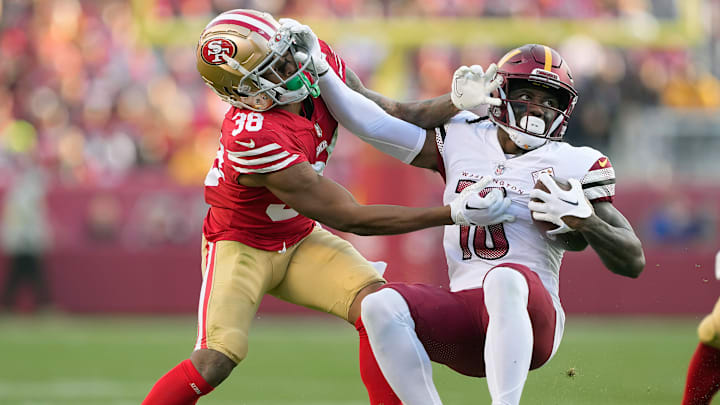 Washington Commanders wide receiver Curtis Samuel (R) is tackled by San Francisco 49ers cornerback Deommodore Lenoir (L)