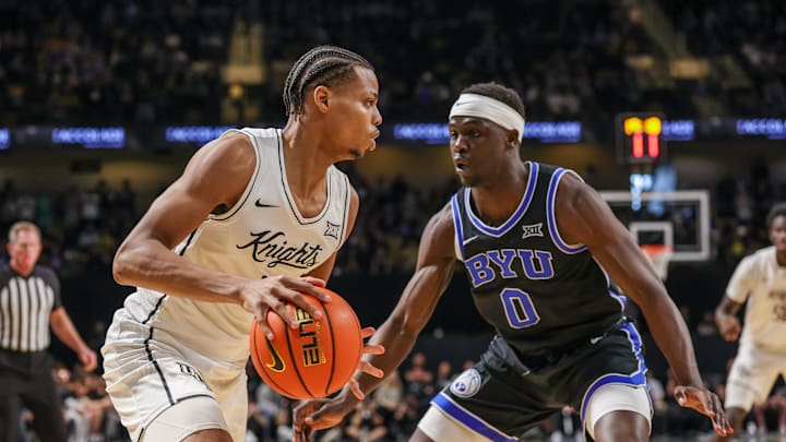 Feb 1, 2025; Orlando, Florida, USA; UCF Knights guard Keyshawn Hall (4) handles the ball in front of Brigham Young Cougars forward Mawot Mag (0) during the first half at Addition Financial Arena. Mandatory Credit: Mike Watters-Imagn Images