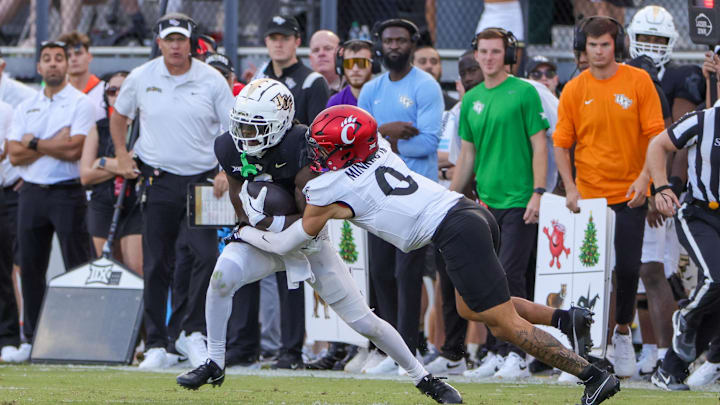 Oct 12, 2024; Orlando, Florida, USA; UCF Knights wide receiver Kobe Hudson (2) is tackled by Cincinnati Bearcats defensive back Josh Minkins (0) during the second half at FBC Mortgage Stadium. Mandatory Credit: Mike Watters-Imagn Images Oct 12, 2024; Orlando, Florida, USA; UCF Knights wide receiver Kobe Hudson (2) is tackled by Cincinnati Bearcats defensive back Josh Minkins (0) during the second half at FBC Mortgage Stadium. Mandatory Credit: Mike Watters-Imagn Images