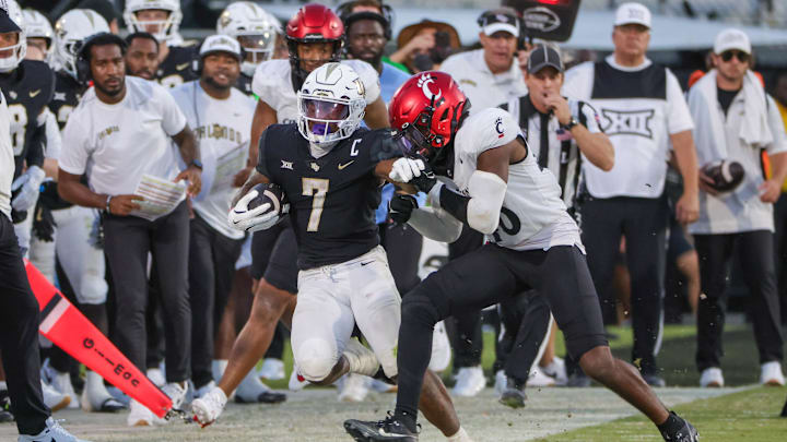 Oct 12, 2024; Orlando, Florida, USA; UCF Knights running back RJ Harvey (7) is forced out of bounds by Cincinnati Bearcats linebacker Antwan Peek Jr. (46) during the second half at FBC Mortgage Stadium. Mandatory Credit: Mike Watters-Imagn Images