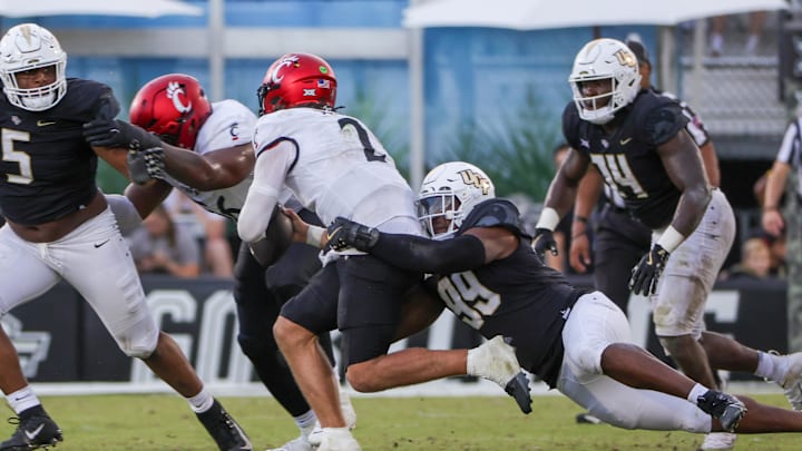 Oct 12, 2024; Orlando, Florida, USA; Cincinnati Bearcats quarterback Brendan Sorsby (2) is sacked by UCF Knights defensive end Jamaal Johnson (99) during the second half at FBC Mortgage Stadium. Mandatory Credit: Mike Watters-Imagn Images Oct 12, 2024; Orlando, Florida, USA; Cincinnati Bearcats quarterback Brendan Sorsby (2) is sacked by UCF Knights defensive end Jamaal Johnson (99) during the second half at FBC Mortgage Stadium. Mandatory Credit: Mike Watters-Imagn Images