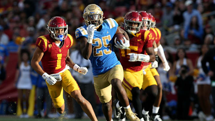 Nov 18, 2023; Los Angeles, California, USA; UCLA Bruins running back TJ Harden (25) runs against USC Trojans cornerback Domani Jackson (1) and safety Anthony Beavers Jr. (15) during the third quarter at United Airlines Field at Los Angeles Memorial Coliseum. Mandatory Credit: Jason Parkhurst-Imagn Images Nov 18, 2023; Los Angeles, California, USA; UCLA Bruins running back TJ Harden (25) runs against USC Trojans cornerback Domani Jackson (1) and safety Anthony Beavers Jr. (15) during the third quarter at United Airlines Field at Los Angeles Memorial Coliseum. Mandatory Credit: Jason Parkhurst-Imagn Images