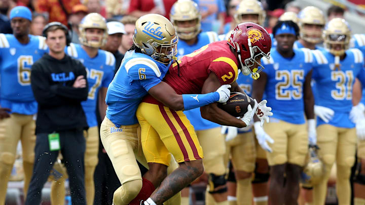 Nov 18, 2023; Los Angeles, California, USA; UCLA Bruins defensive back John Humphrey (6) tackles USC Trojans wide receiver Brenden Rice (2) during the first quarter at United Airlines Field at Los Angeles Memorial Coliseum. Mandatory Credit: Jason Parkhurst-Imagn Images