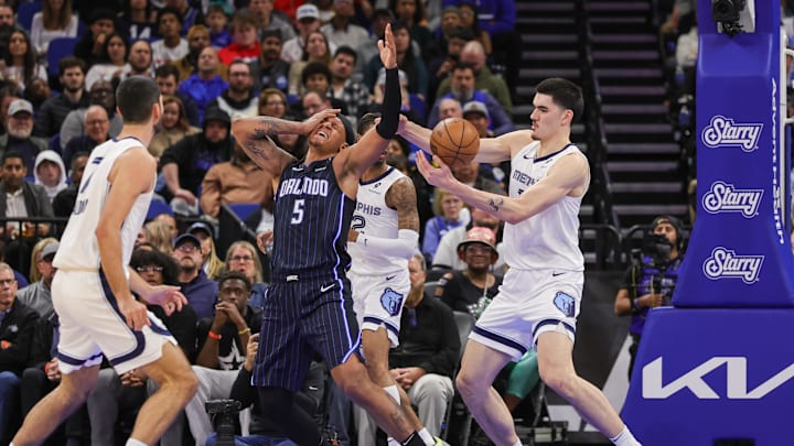 Feb 21, 2025; Orlando, Florida, USA; Orlando Magic forward Paolo Banchero (5) is fouled by Memphis Grizzlies guard Ja Morant (12) during the second half at Kia Center. Mandatory Credit: Mike Watters-Imagn Images Feb 21, 2025; Orlando, Florida, USA; Orlando Magic forward Paolo Banchero (5) is fouled by Memphis Grizzlies guard Ja Morant (12) during the second half at Kia Center. Mandatory Credit: Mike Watters-Imagn Images
