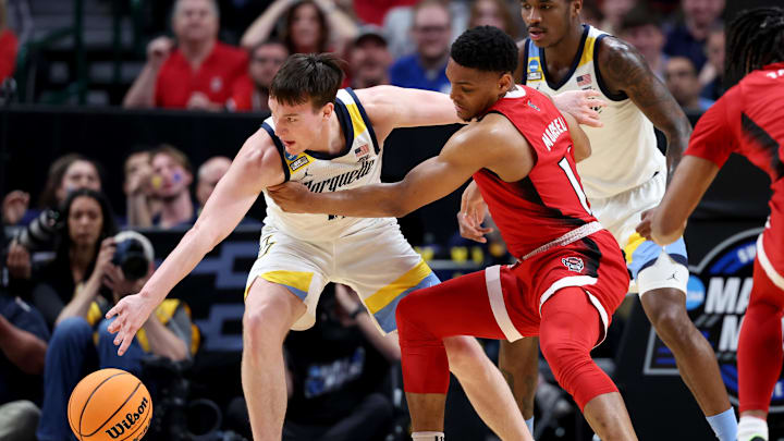 Mar 29, 2024; Dallas, TX, USA; Marquette Golden Eagles guard Tyler Kolek (11) and North Carolina State Wolfpack guard Casey Morsell (14) fight for a loose ball during the first half in the semifinals of the South Regional of the 2024 NCAA Tournament at American Airlines Center. Mandatory Credit: Kevin Jairaj-Imagn Images 