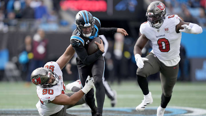 Dec 21, 2025; Charlotte, North Carolina, USA; Tampa Bay Buccaneers defensive end Logan Hall (90) and linebacker Yaya Diaby (0) chase Carolina Panthers quarterback Bryce Young (9) during the second half at Bank of America Stadium. Mandatory Credit: Jim Dedmon-Imagn Images