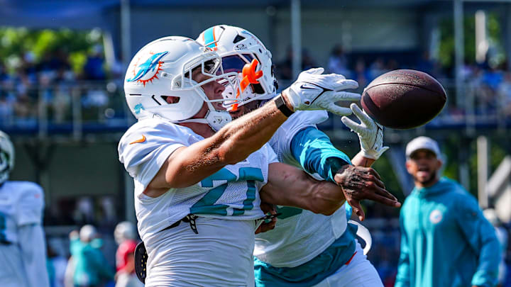 Miami Dolphins CB Ethan Bonner (27) holds out the ball, while CB Jack Jones (23) knocks it away, during the joint practice with the Miami Dolphins at the Lions headquarters and training facility in Allen Park, Thursday, Aug. 14 2025