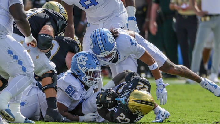 Sep 20, 2025; Orlando, Florida, USA; UCF Knights running back Myles Montgomery (22) is tackled by North Carolina Tar Heels defensive lineman Leroy Jackson (91) during the first quarter at the Bounce House Stadium. 