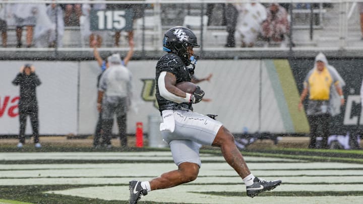 Nov 2, 2024; Orlando, Florida, USA; UCF Knights running back RJ Harvey (7) scores a touchdown against the Arizona Wildcats during the first quarter at FBC Mortgage Stadium. Mandatory Credit: Mike Watters-Imagn Images