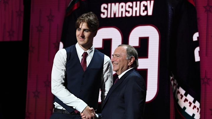 Jun 28, 2023; Nashville, Tennessee, USA; Arizona Coyotes draft pick Dmitriy Simashev shakes hands with NHL commissioner Gary Bettman after being selected with the sixth pick in round one of the 2023 NHL Draft at Bridgestone Arena. Mandatory Credit: Christopher Hanewinckel-Imagn Images