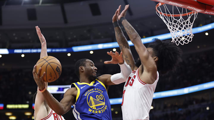 Jan 12, 2024; Chicago, Illinois, USA; Golden State Warriors forward Jonathan Kuminga (00) shoots against Chicago Bulls guard Zach LaVine (8) and guard Coby White (0) during the first half at United Center. Mandatory Credit: Kamil Krzaczynski-Imagn Images