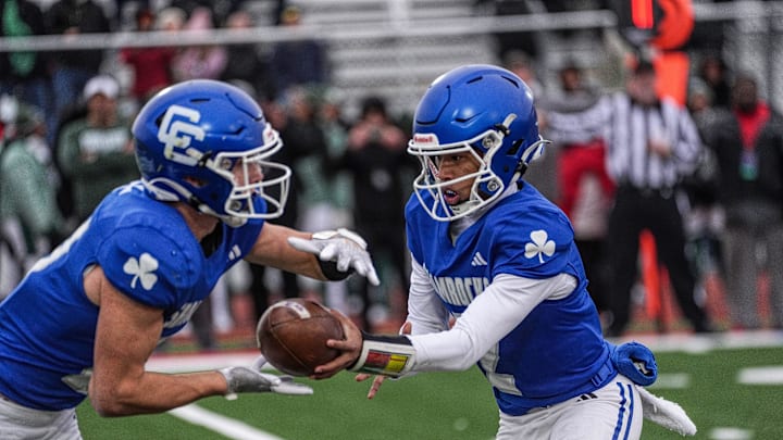 Novi Detroit Catholic Central QB Skyler Hunter hands the ball to Jaden Pydyn in the fourth quarter looking for a first down during MHSAA semifinals at Troy Athens high school on Saturday, Nov. 23, 2024.