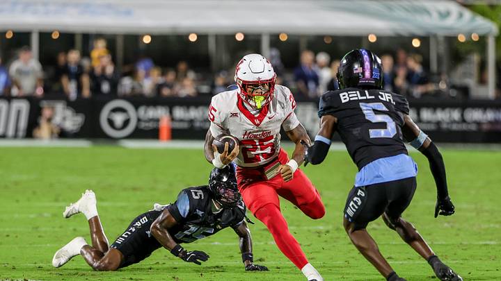 Nov 7, 2025; Orlando, Florida, USA; Houston Cougars running back DJ Butler (25) avoids a tackle during the first quarter against the UCF Knights at Acrisure Bounce House. Mandatory Credit: Mike Watters-Imagn Images
