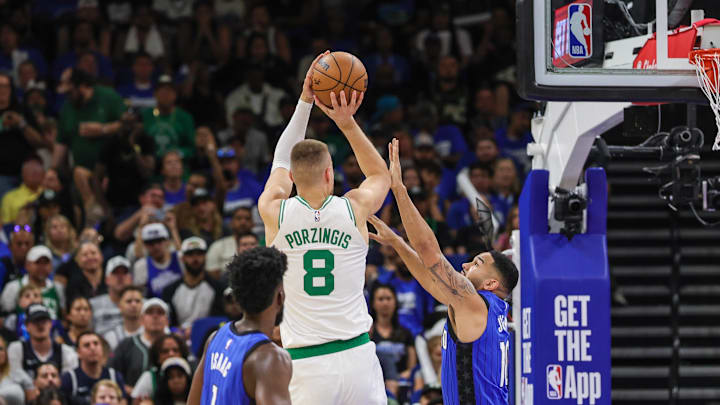 Apr 25, 2025; Orlando, Florida, USA; Boston Celtics center Kristaps Porzingis (8) shoots against Orlando Magic guard Cory Joseph (10) during the second quarter of game three of first round for the 2024 NBA Playoffs at Kia Center. Mandatory Credit: Mike Watters-Imagn Images