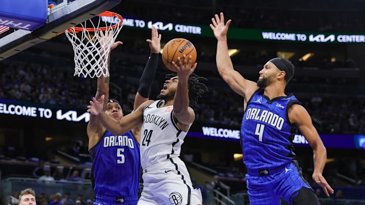 Oct 25, 2024; Orlando, Florida, USA; Brooklyn Nets guard Cam Thomas (24) goes to the basket against Orlando Magic forward Paolo Banchero (5) and guard Jalen Suggs (4) during the second quarter at Kia Center. Mandatory Credit: Mike Watters-Imagn Images Oct 25, 2024; Orlando, Florida, USA; Brooklyn Nets guard Cam Thomas (24) goes to the basket against Orlando Magic forward Paolo Banchero (5) and guard Jalen Suggs (4) during the second quarter at Kia Center. Mandatory Credit: Mike Watters-Imagn Images