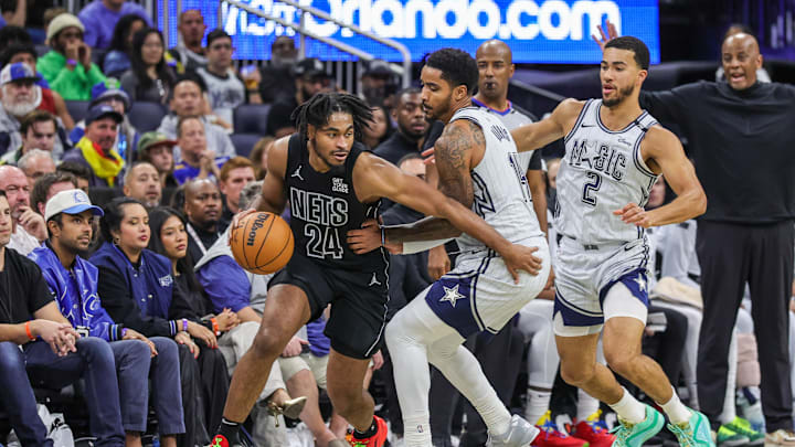 Dec 29, 2024; Orlando, Florida, USA; Brooklyn Nets guard Cam Thomas (24) drives around Orlando Magic guard Gary Harris (14) during the second half at Kia Center. Mandatory Credit: Mike Watters-Imagn Images