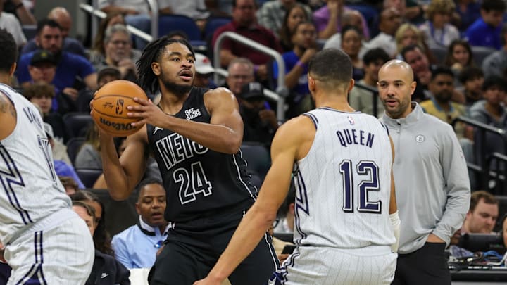 Dec 29, 2024; Orlando, Florida, USA; Brooklyn Nets guard Cam Thomas (24) looks to pass in front of Orlando Magic guard Trevelin Queen (12) during the second quarter at Kia Center. Mandatory Credit: Mike Watters-Imagn Images