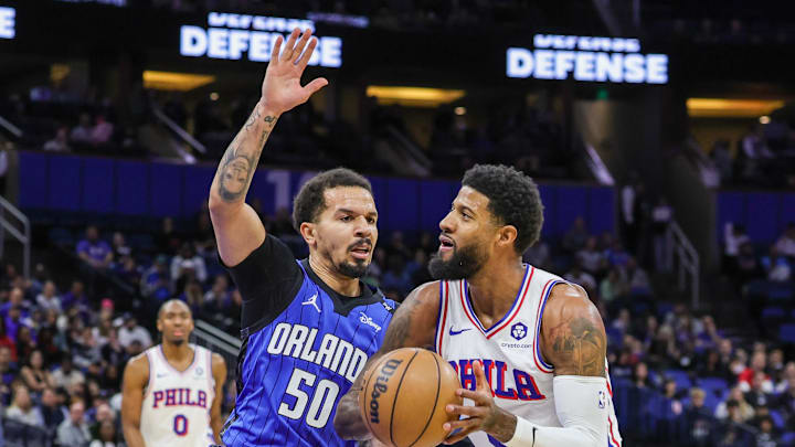 Jan 12, 2025; Orlando, Florida, USA; Orlando Magic guard Cole Anthony (50) defends Philadelphia 76ers forward Paul George (8) during the first quarter at Kia Center. Mandatory Credit: Mike Watters-Imagn Images