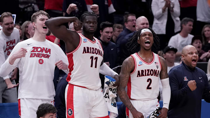 Mar 23, 2024; Salt Lake City, UT, USA; Arizona Wildcats center Oumar Ballo (11) and guard Caleb Love (2) react to a play with teammates during the second half in the second round of the 2024 NCAA Tournament against the Dayton Flyers at Vivint Smart Home Arena-Delta Center. Mandatory Credit: Gabriel Mayberry-Imagn Images Mar 23, 2024; Salt Lake City, UT, USA; Arizona Wildcats center Oumar Ballo (11) and guard Caleb Love (2) react to a play with teammates during the second half in the second round of the 2024 NCAA Tournament against the Dayton Flyers at Vivint Smart Home Arena-Delta Center. Mandatory Credit: Gabriel Mayberry-Imagn Images