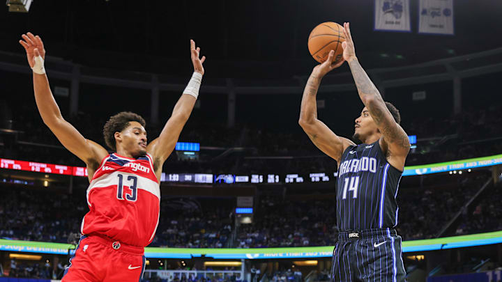 Nov 10, 2024; Orlando, Florida, USA; Orlando Magic guard Gary Harris (14) shoots a three point basket against Washington Wizards guard Jordan Poole (13) during the second half at Kia Center. Mandatory Credit: Mike Watters-Imagn Images