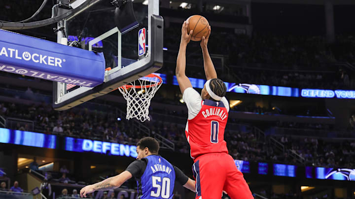 Feb 23, 2025; Orlando, Florida, USA; Washington Wizards guard Bilal Coulibaly (0) dunks over Orlando Magic guard Cole Anthony (50) during the second quarter at Kia Center. Mandatory Credit: Mike Watters-Imagn Images