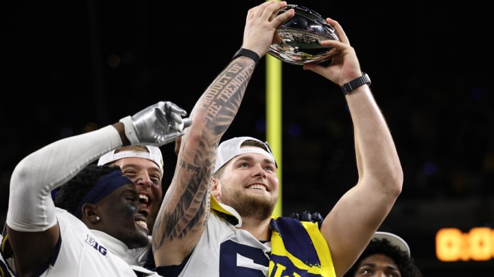 Dec 2, 2023; Indianapolis, IN, USA; Michigan Wolverines offensive lineman Zak Zinter (65) raises the