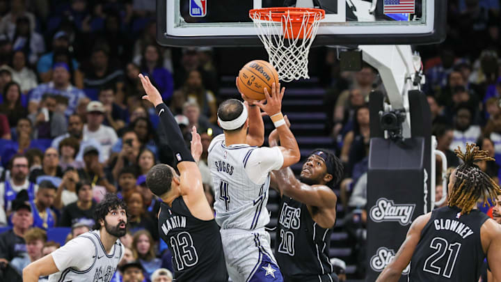Dec 29, 2024; Orlando, Florida, USA; Orlando Magic guard Jalen Suggs (4) goes to the basket against Brooklyn Nets center Day'Ron Sharpe (20) and guard Tyrese Martin (13) during the second quarter at Kia Center. Mandatory Credit: Mike Watters-Imagn Images