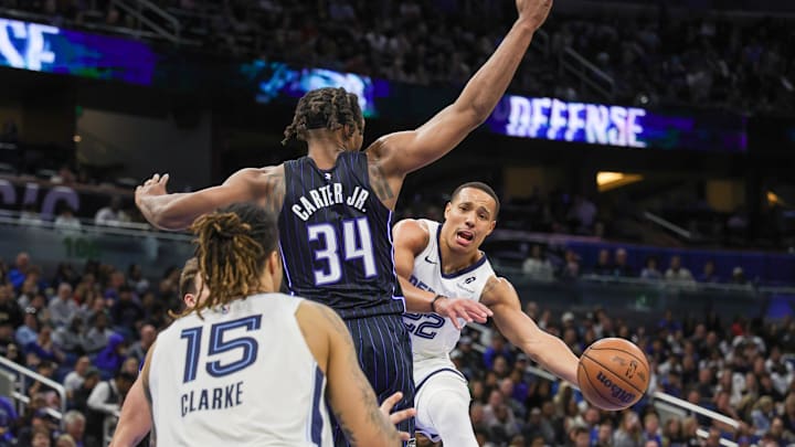 Feb 21, 2025; Orlando, Florida, USA; Memphis Grizzlies guard Desmond Bane (22) passes the ball around Orlando Magic center Wendell Carter Jr. (34) during the second half at Kia Center. Mandatory Credit: Mike Watters-Imagn Images Feb 21, 2025; Orlando, Florida, USA; Memphis Grizzlies guard Desmond Bane (22) passes the ball around Orlando Magic center Wendell Carter Jr. (34) during the second half at Kia Center. Mandatory Credit: Mike Watters-Imagn Images